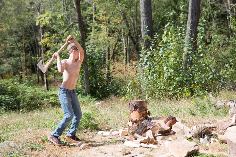 Boy chopping wood with ax