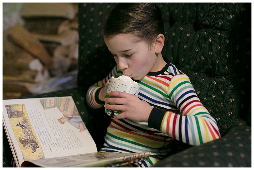 Reading a book with hot chocolate and Primary pajamas.